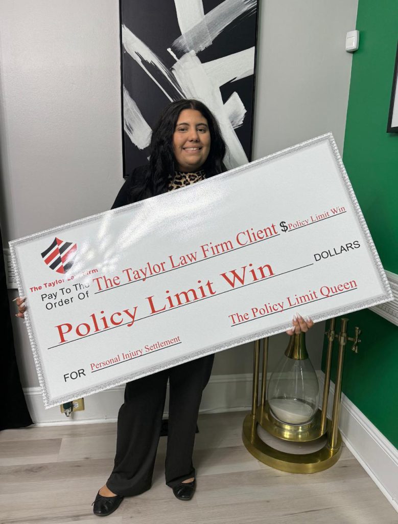 Taylor Law Firm client holding a Policy Limit Win check
