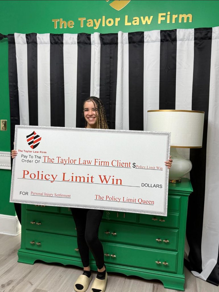 Taylor Law Firm client holding a Policy Limit Win check